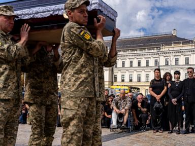 Source-feed image associated with A pregnant soldier mourns her 21-year-old husband at his funeral in Ukraine
