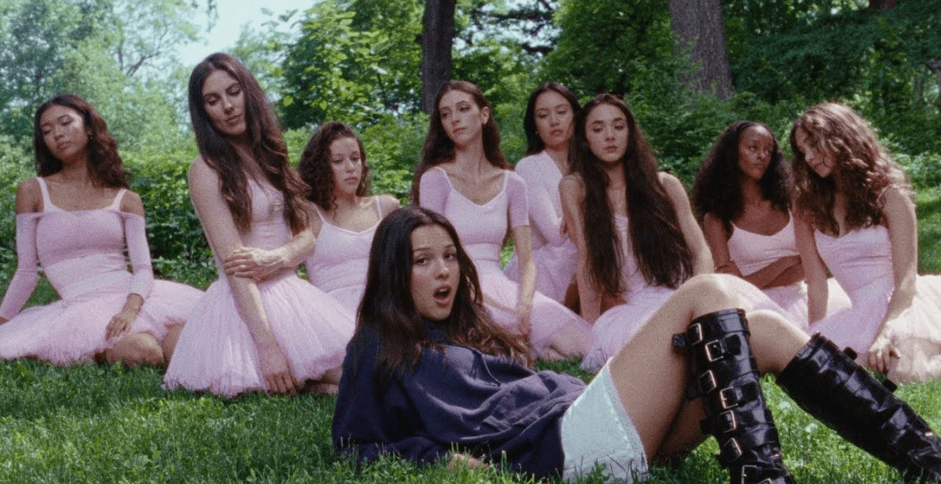 Source-feed image associated with Watch Olivia Rodrigo Bring in the Ballerinas in “Stupid Song” Video