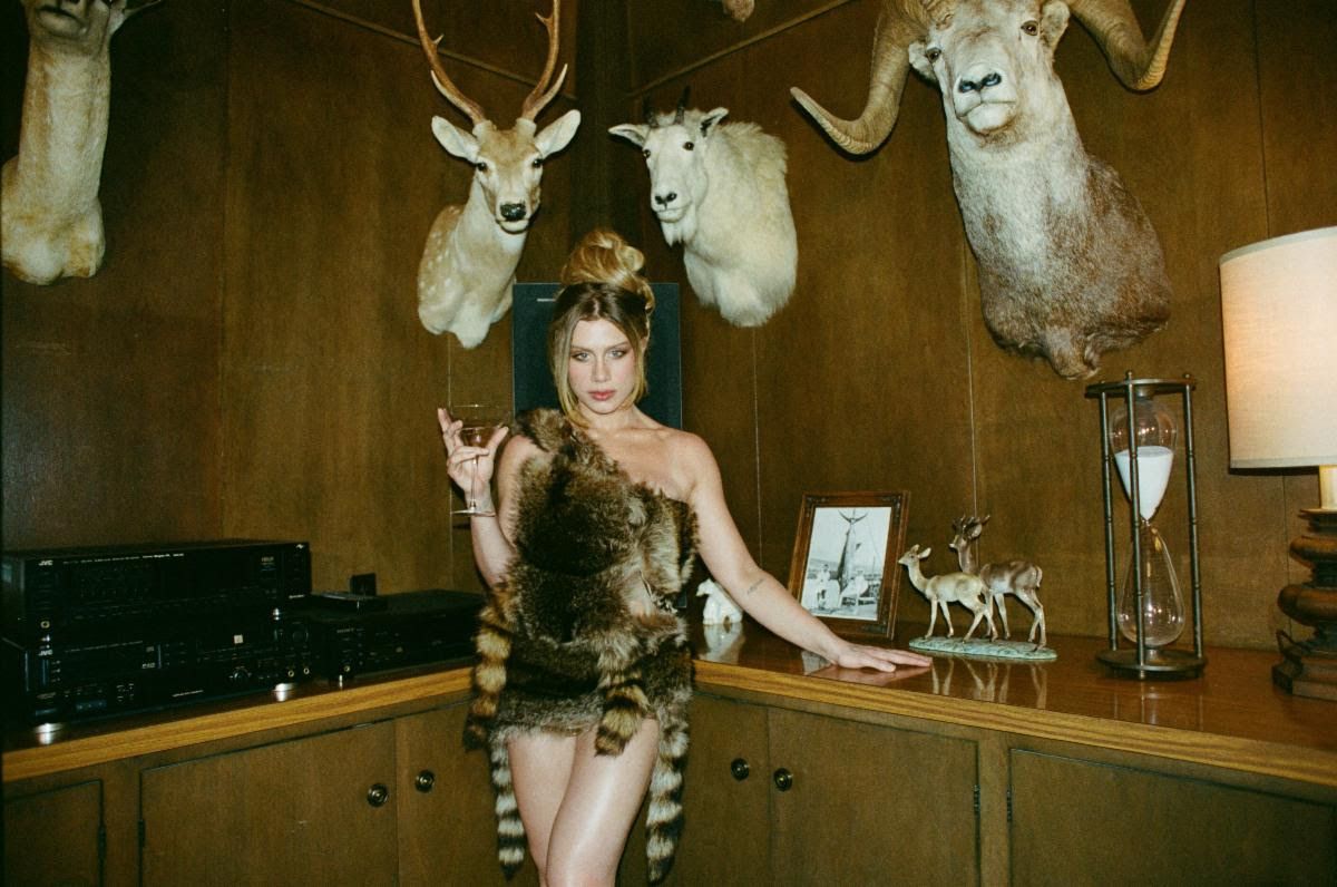 Image from linked report: Watch Slayyyter Rock a Raccoon Pelt in “I Think He’s Got a Girl” Video