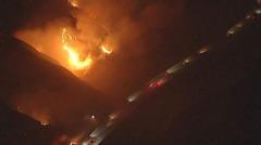 Source-feed image associated with Watch: California wildfires rage near passing vehicles