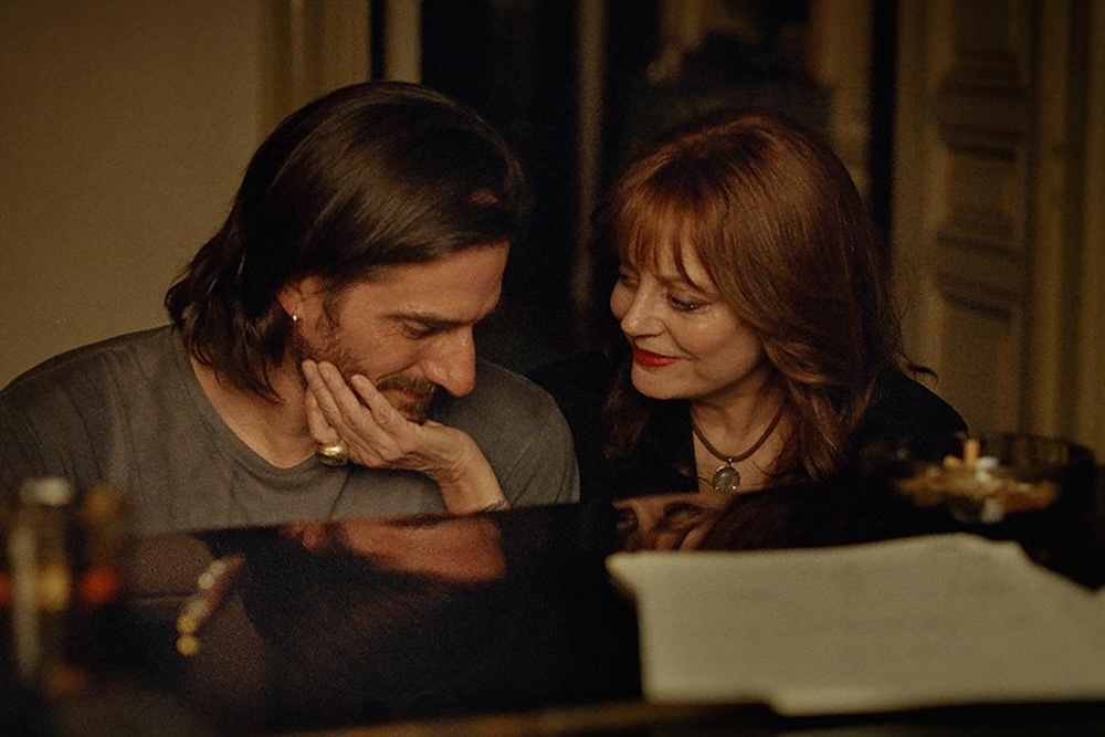 Source-feed image associated with ‘The Echo Chamber’ Review: Luca Marinelli, Alicia Vikander and Susan Sarandon Reverberate Through a Smoky, Somber Single-Location Love Story