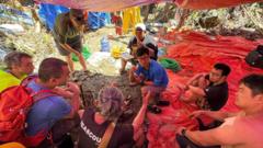 Source-feed image associated with Laos cave survivors help with plan to find last two missing men
