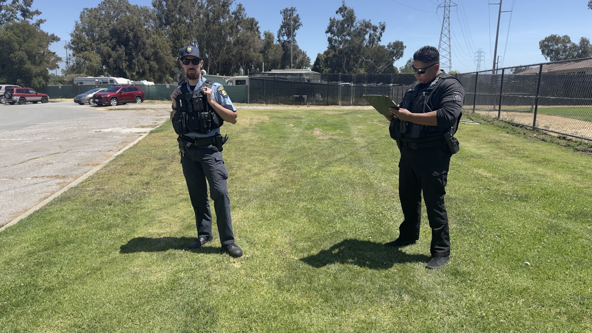 Two Palo Alto police officers standing on grass near a parking lot on June 1, 2026
