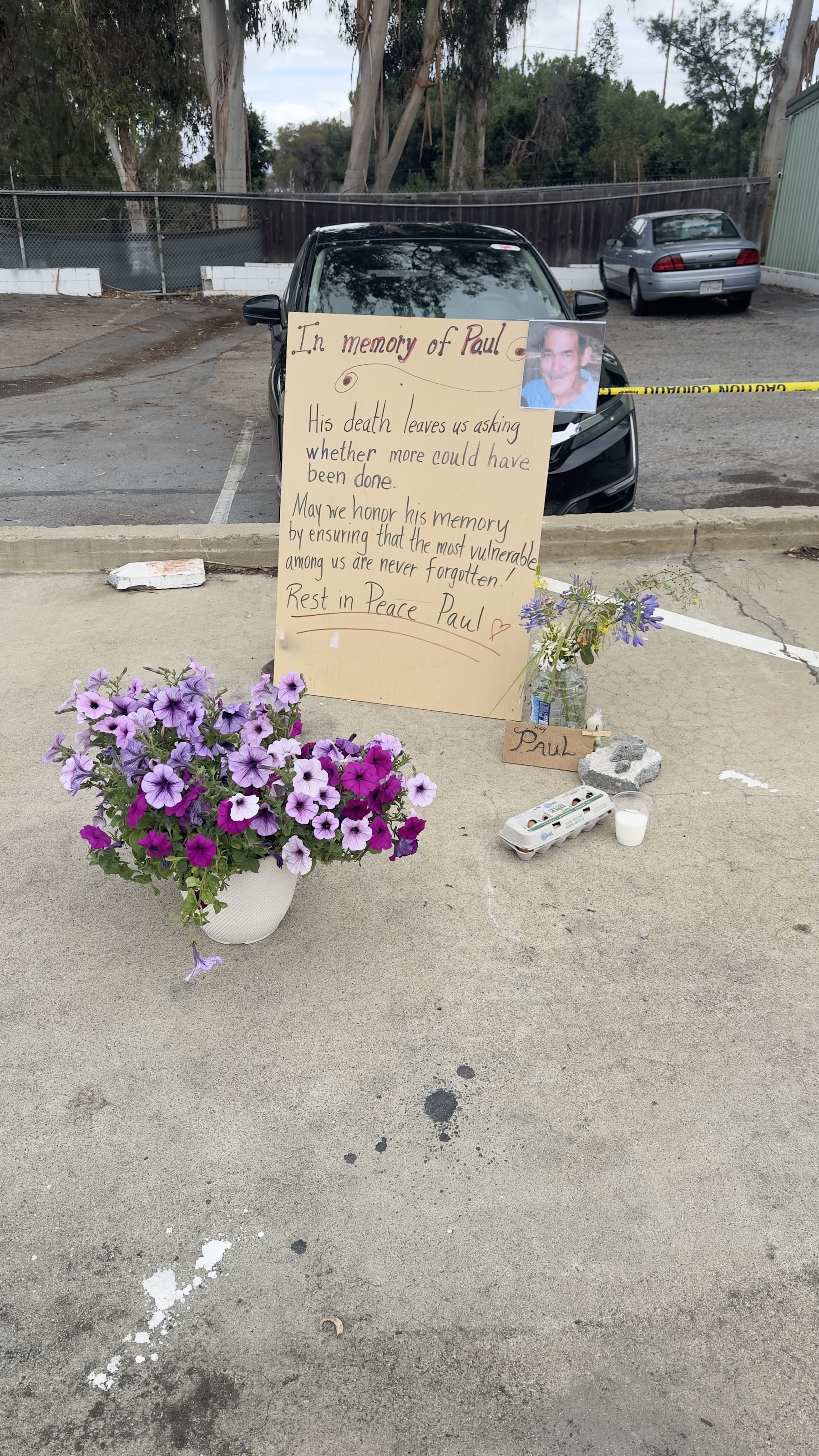 Memorial sign and flowers for Paul A. at the Geng safe-parking site